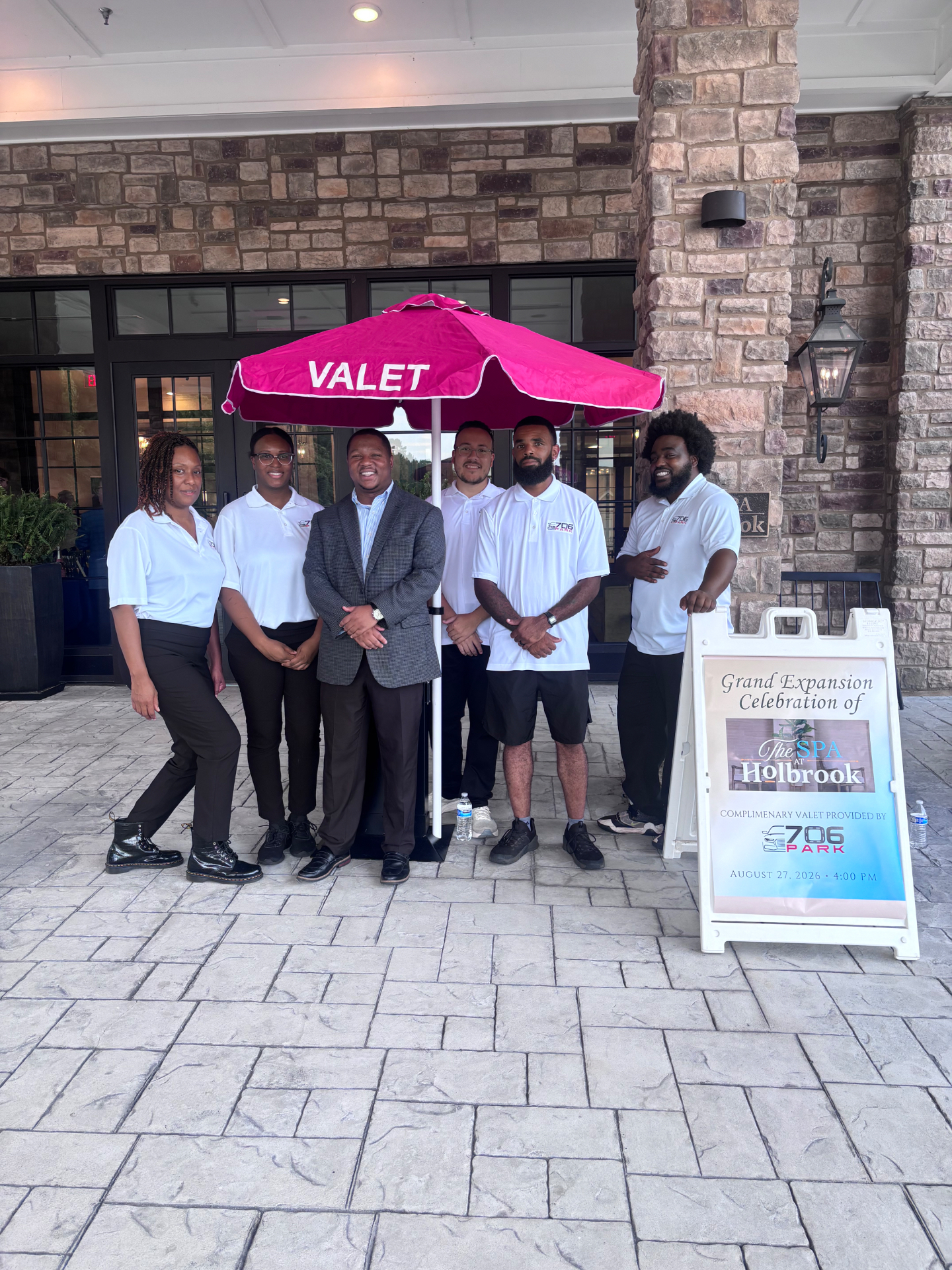 706 Parking Management team in white polos under a branded valet umbrella at The Spa at Holbrook grand expansion event
