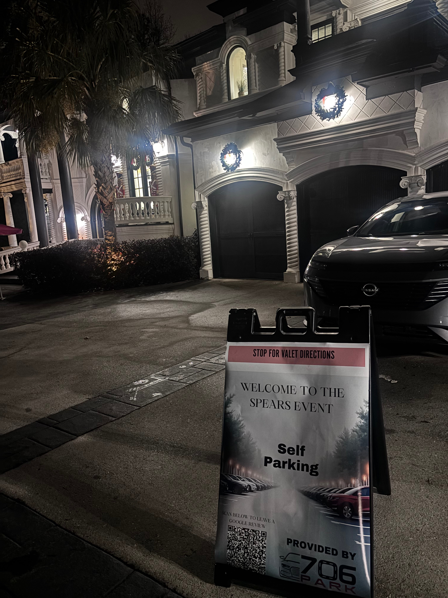 706 Park stop-for-valet-directions sign in the driveway of a large Atlanta home decorated for the holidays at night