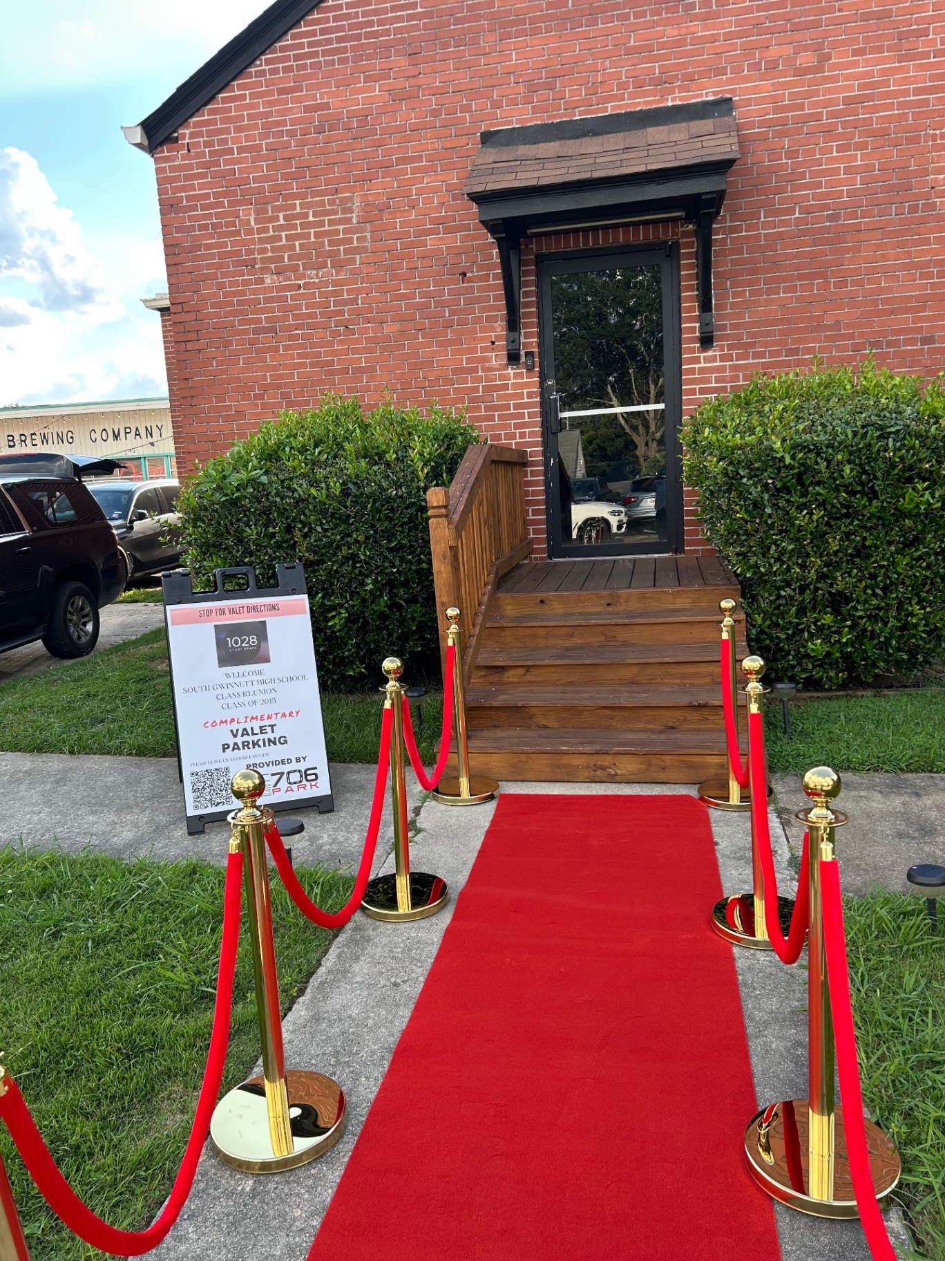 Red carpet with gold stanchions and a 706 Park complimentary valet parking sign outside an event space